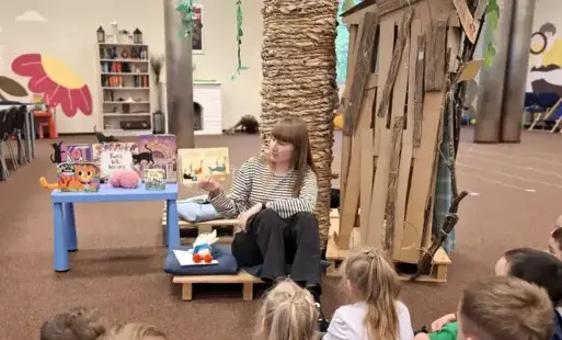 Pani bibliotekarka czyta dzieciom książkę.