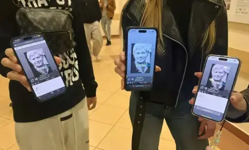 trzy osoby pokazują swoje telefony z wyświetlonym wizerunkiem Z.Herberta