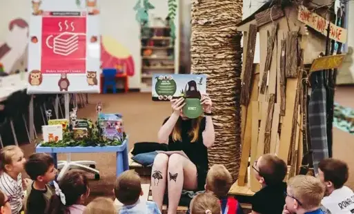 Bibliotekarka czyta dzieciom książkę. 