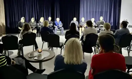 Występ na scenie w pomieszczeniu, oglądany przez publiczność.