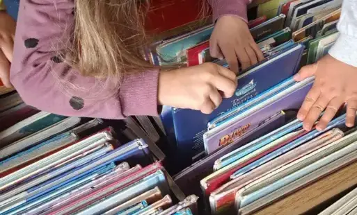Dzieci przeglądają książeczki znajdujące się w skrzyni.