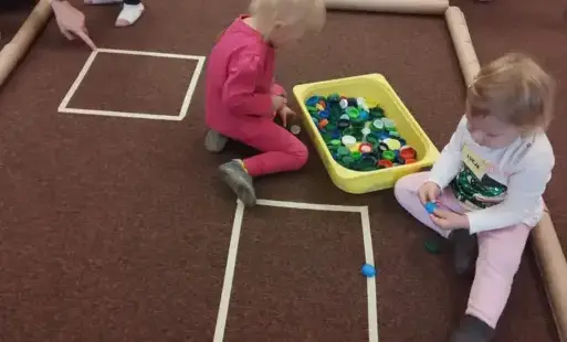 Dzieci budują dom z dostępnych materiałów takich jak nakrętki czy tuby.