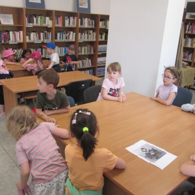 Dzieci siedzące przy stołach układające puzzle z pociętej kartki A4 z wizerunkiem maskotki Gorzowa Wielkopolskiego, Gorzusiem. kliknięcie powoduje powiększenie zdjęcia