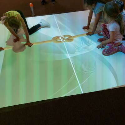 Dzieci podczas zabawy z podłogą interaktywną. Kliknięcie powoduje powiększenie zdjęcia