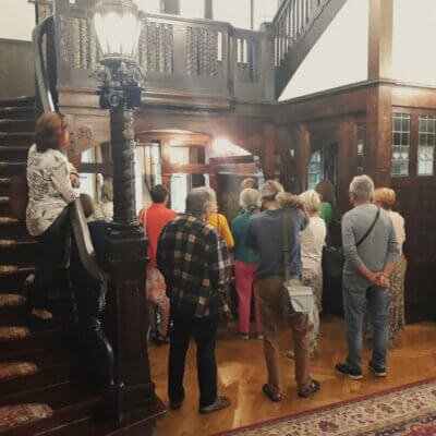 Zdjęcie w zabytkowym holu Willi Lehmanna. Widać stojących tyłem uczestników spotkania. Kliknięcie powoduje powiększenie zdjęcia.