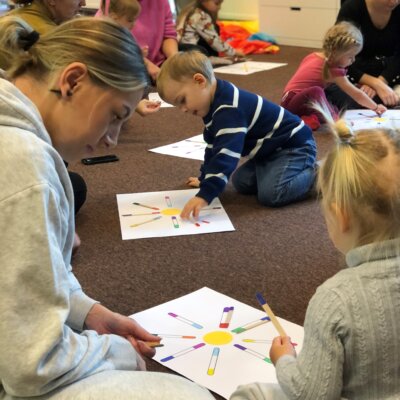 Dzieci wraz z rodzicami układają patyczki pod kolor na przygotowanym wzorze. Kliknięcie powoduje powiększenie zdjęcia.