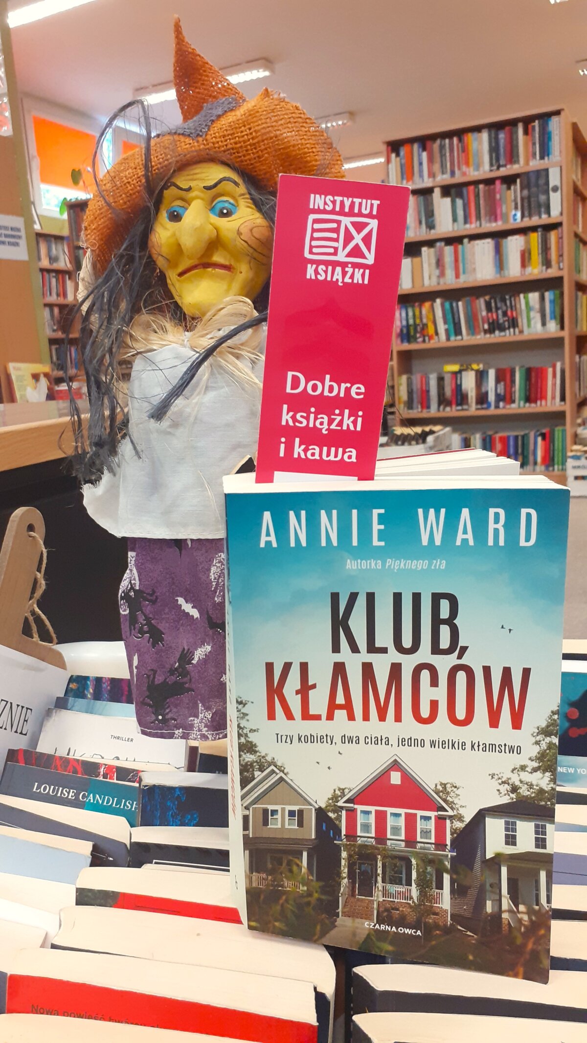wyeksponowana książka „ Klub kłamców” Annie Wart. W tle postać czarownicy, nawiązująca do charakterów bohaterów książki.