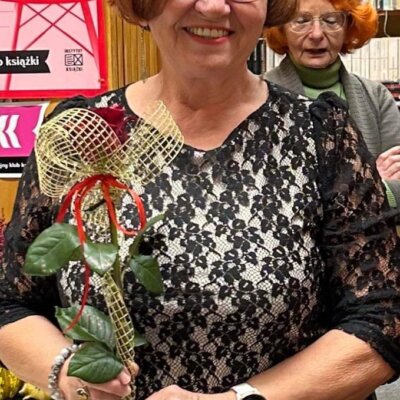 13-Na zdjęciu pani Krystyna Jarosz trzymająca w dłoniach różę.