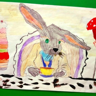 2.Praca nagrodzona w konkursie plastycznym „Z Alicją w Krainie Czarów, malowana kredkami i farbami przedstawiająca królika siedzącego przy stole nakrytym do podwieczorku
