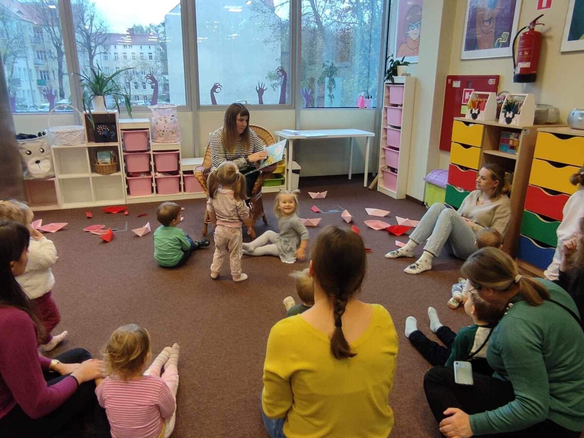 Dzieci uważnie słuchają bajki czytanej przez Panią Bibliotekarkę.