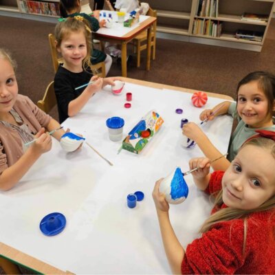 Cztery dziewczynki siedzą przy stole i malują styropianowe bombki. Kliknięcie w obrazek spowoduje powiększenie.