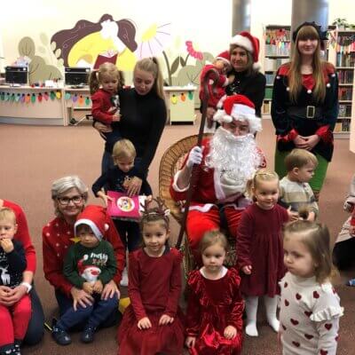 Dzieci wraz z opiekunami pozują do zdjęcia ze Świętym Mikołajem i Panią Elf. Kliknięcie w obrazek spowoduje powiększenie.