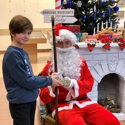 Chłopiec trzyma w dłoni prezent, który otrzymał od Świętego Mikołaja. Kliknięcie w obrazek spowoduje powiększenie.