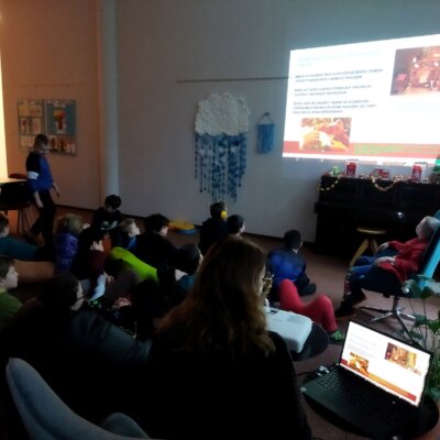 Grupa dzieci ogląda prezentację wyświetlaną na ścianie. Kliknięcie powoduje powiększenia zdjęcia.