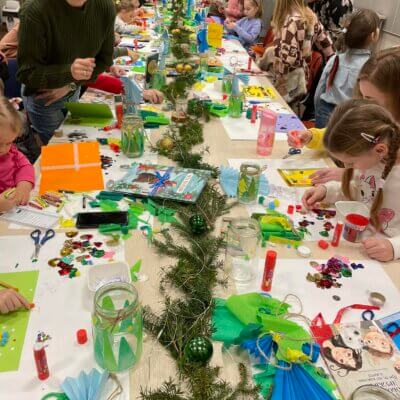 Warsztaty tworzenia ozdób świątecznych dla dzieci. Dzieci wykonują ozdoby świąteczne przy stole, przy pomocy bibliotekarek. Kliknięcie w zdjęcie spowoduje powiększenie.