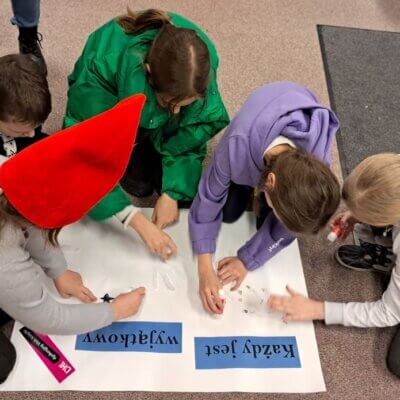 dzieci wspólnie przykleją wycięte dłonie na duży arkusz białego papieru. Klikniecie powoduje powiększenie zdjęcia.