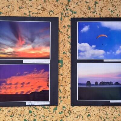 Fragment wystawy ze zdjęciami nieba podczas zachodu słońca oraz unoszącego się latawca i paralotni. Kliknięcie w obrazek spowoduje powiększenie.