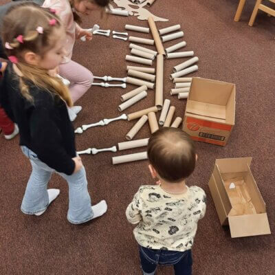 Dzieci układają szkielet dinozaura z rolek i kości wykonanych z glinki. Kliknięcie w obrazek spowoduje powiększenie.