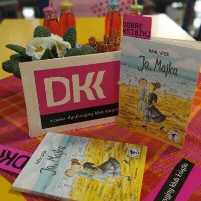 Na stole ustawione są książki, kwiatek i zakładki DKK. Kliknięcie w obrazek spowoduje powiększenie.