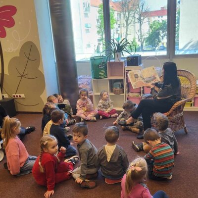 Dzieci w skupieniu słuchają książki czytanej przez Panią Bibliotekarkę. Kliknięcie w obrazek spowoduje powiększenie.