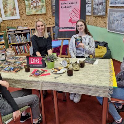 Przy stole siedzą trzy uczestniczki DKK z bibliotekarką, uśmiechają się. Kliknięcie w obrazek spowoduje powiększenie.